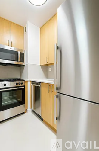 A kitchen with a stainless steel refrigerator, oven, and microwave.