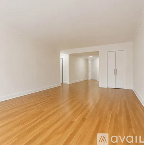 A room with wooden flooring and white walls.