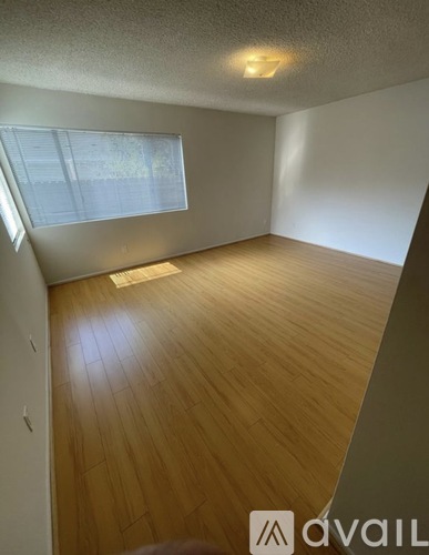 A room with wooden flooring and a window.