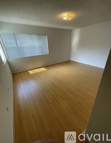 A room with wooden flooring and a window.