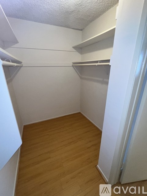 A small, empty room with wooden floors and white walls.