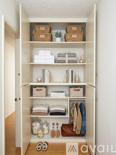 A white closet with shelves and baskets on top.