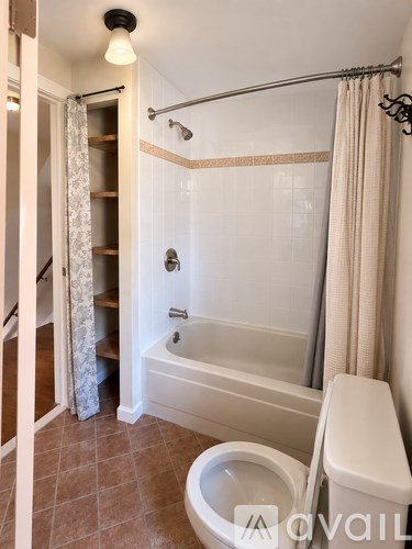 A white bathroom with a toilet, tub, and shower.