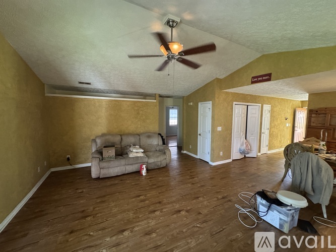 A room with a ceiling fan and a couch.