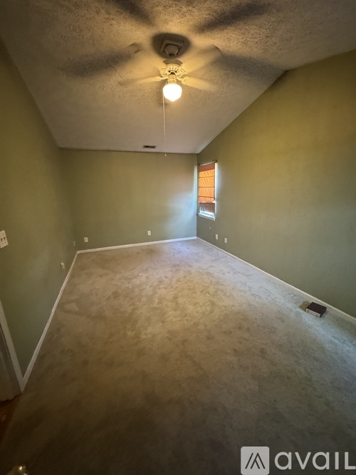 A room with a ceiling fan and a light fixture.