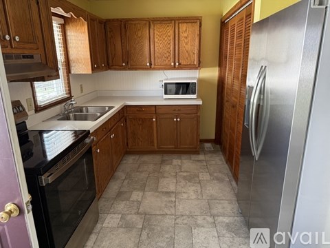 A kitchen with wooden cabinets and a tiled floor.
