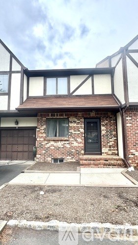 A house with a black door and a window with white curtains.