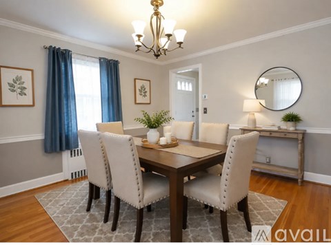 A dining room with a wooden table and chairs.