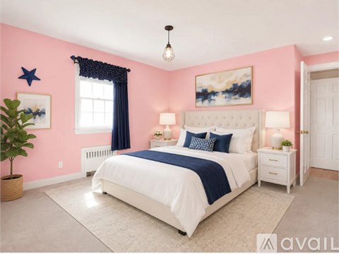 A bedroom with a white bed, blue bedding, and a pink wall.