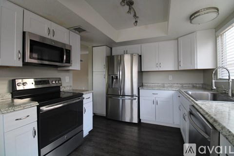 A kitchen with white cabinets and stainless steel appliances.