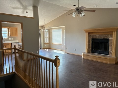 A living room with a fireplace and a ceiling fan.