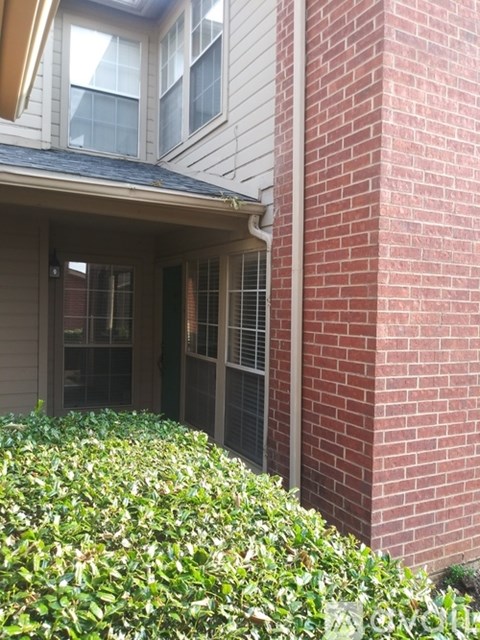 A house with a red brick pillar and a window.