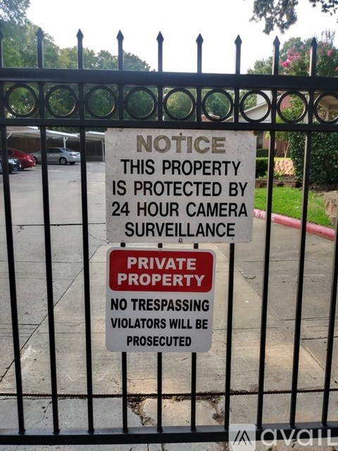 A sign on a gate warning of 24 hour surveillance and prosecution for trespassing.