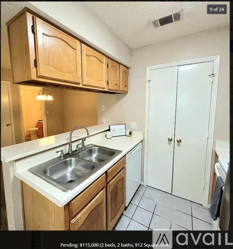 A kitchen with a sink and a white counter top.