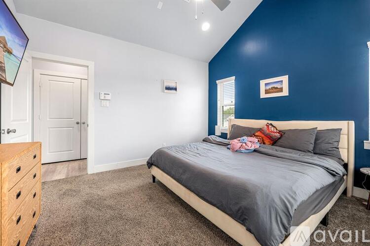 A bedroom with a bed, dresser, and window.