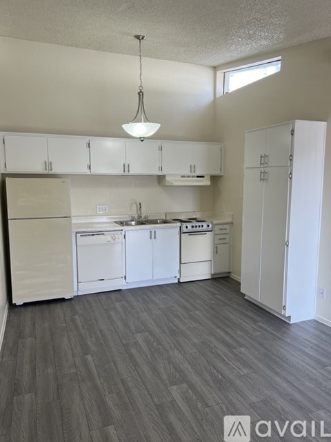 A kitchen with white appliances and cabinets.