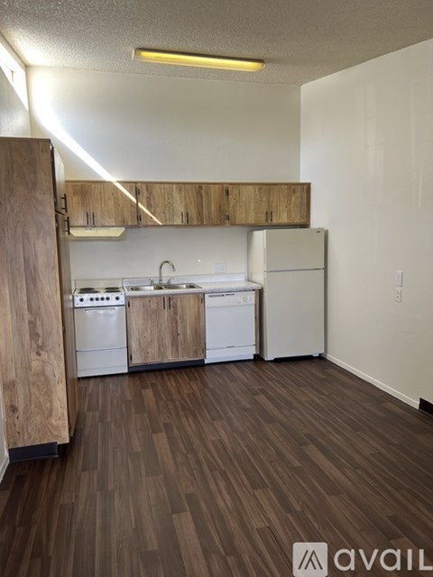 A kitchen with white appliances and wooden cabinets.