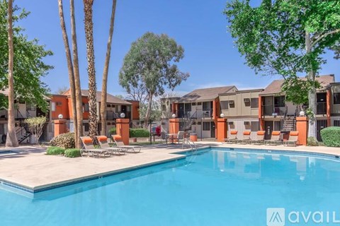 A swimming pool surrounded by orange chairs and palm trees.