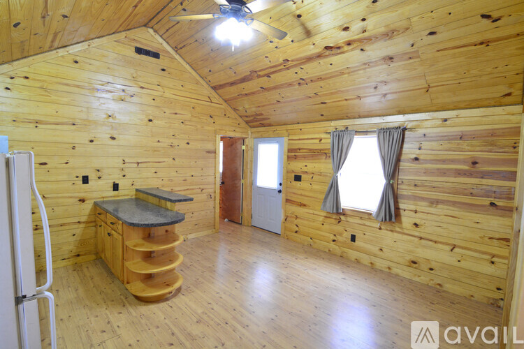 A wooden cabin with a spiral staircase and a window.