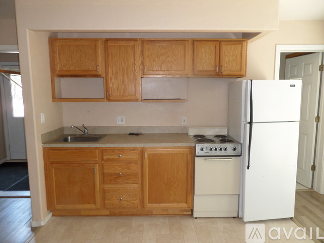 A kitchen with wooden cabinets and a white refrigerator.
