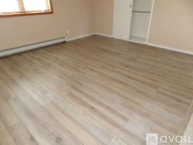 A room with wooden flooring and a window.