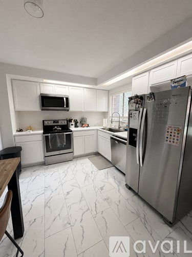 A kitchen with a refrigerator, oven, and microwave.