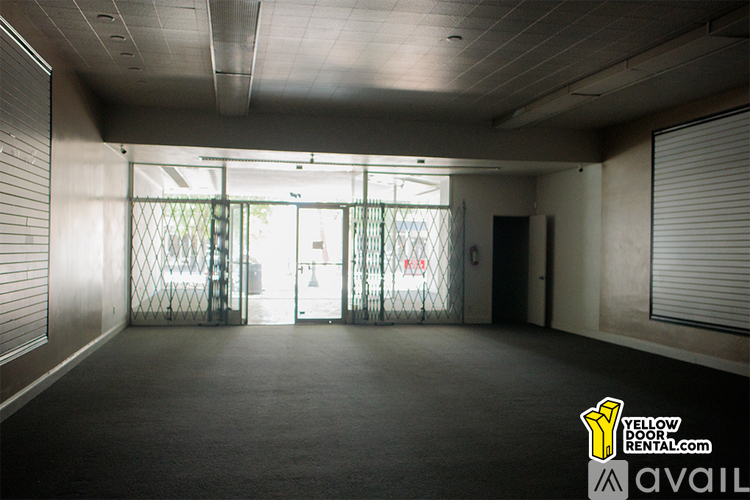 A large empty room with a door and windows.