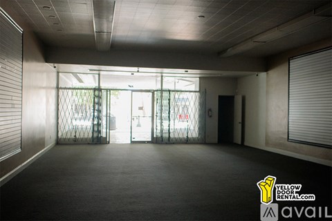 A large empty room with a door and windows.