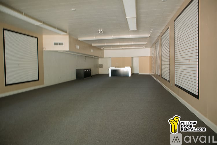 A large, empty room with a carpeted floor and a white ceiling.