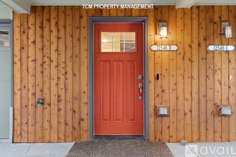 A red door with a glass window is the main focus of the image.