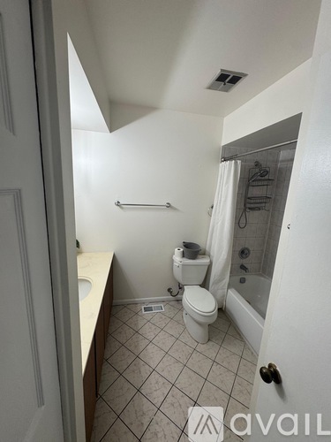 A small bathroom with a toilet, sink and shower.