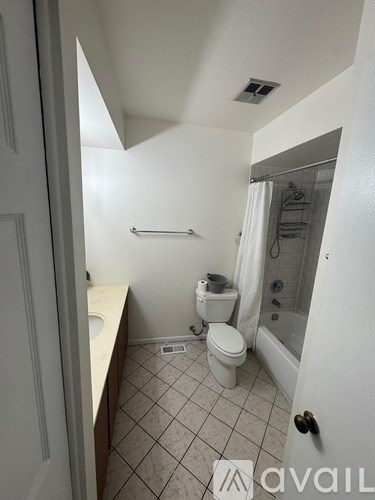 A small bathroom with a toilet, sink and shower.