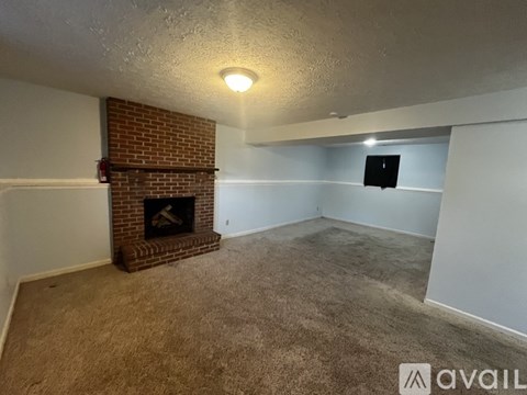 A room with a fireplace and carpeted floor.