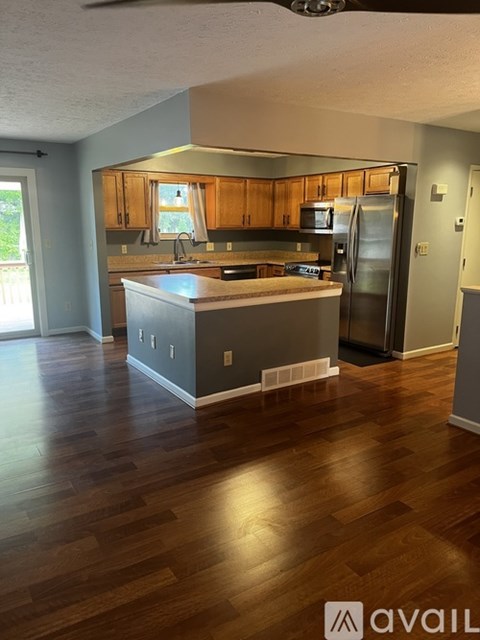 A kitchen with wooden cabinets and a refrigerator.
