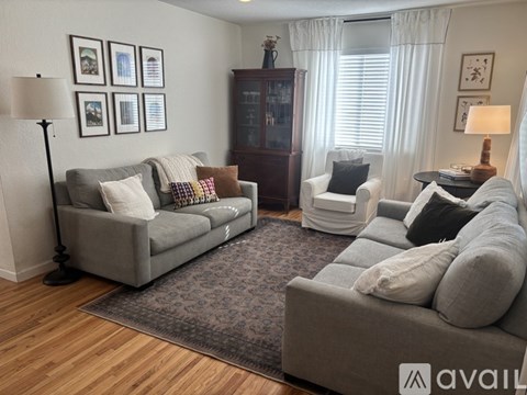 A living room with a grey couch and a white chair.