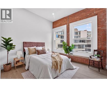 A bedroom with a large bed and a window overlooking a building.