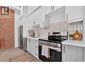 A kitchen with a black stove top oven and white cabinets.