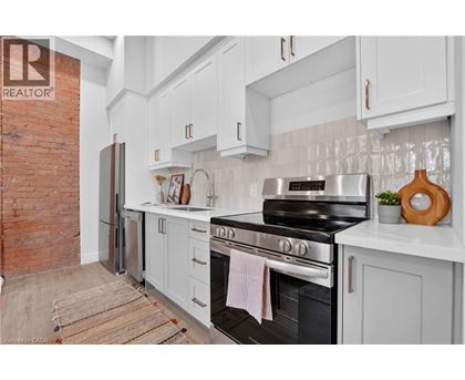 A kitchen with a black stove top oven and white cabinets.