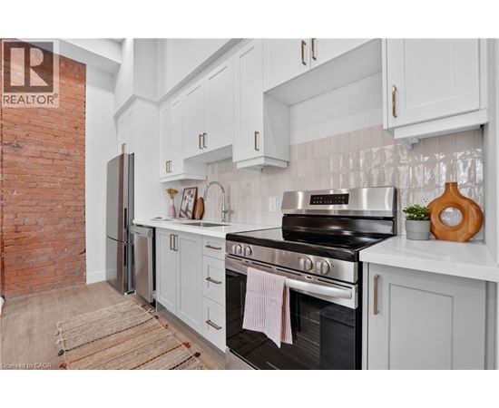 A kitchen with a black stove top oven and white cabinets.