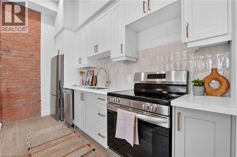 A kitchen with a black stove top oven and white cabinets.