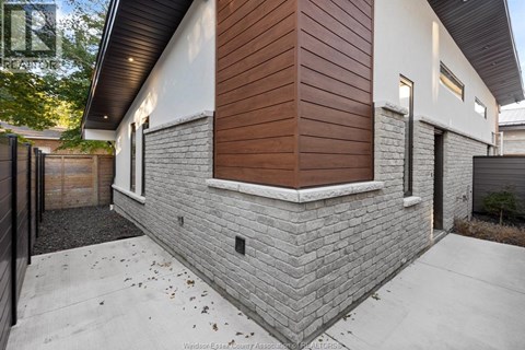 A modern house with a brown siding and a grey brick wall.