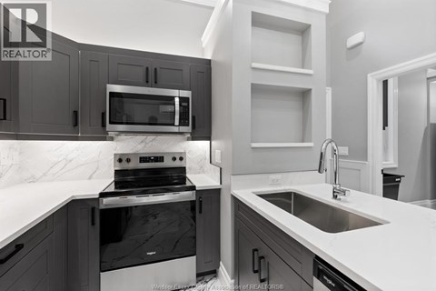 A modern kitchen with a stove, microwave, and oven.