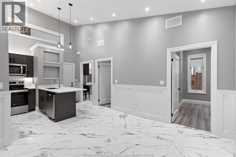 A modern kitchen with a marble floor and white walls.