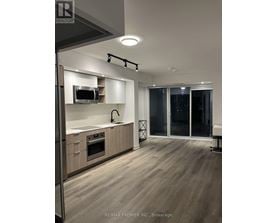 A modern kitchen with wooden floors and a large island.