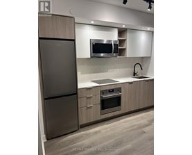 A modern kitchen with a stainless steel refrigerator and oven.
