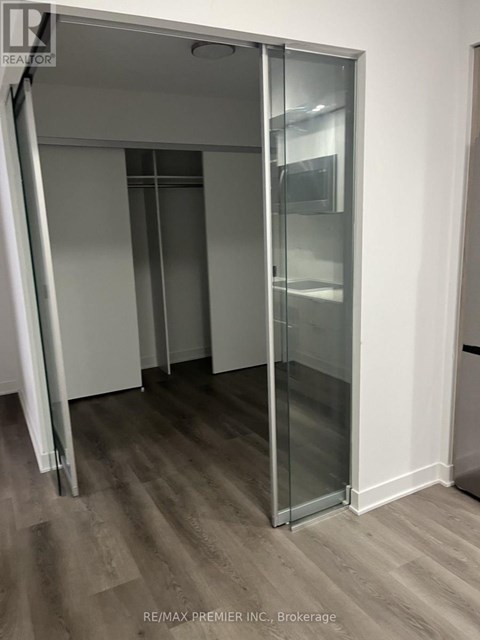 A room with a glass door and wooden flooring.