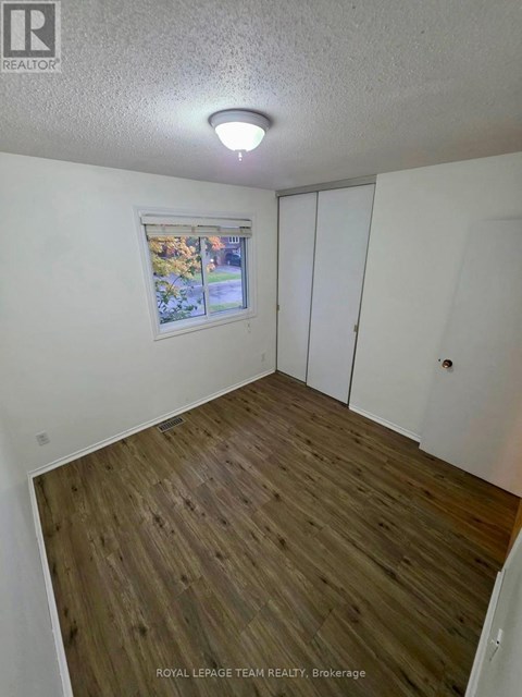 A room with a window and wooden flooring.