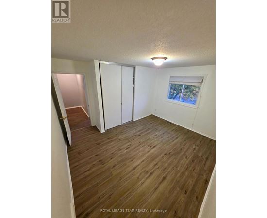 A room with wooden flooring and white walls.