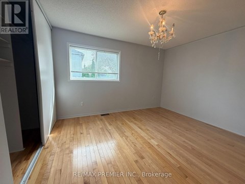 A room with wooden flooring and a chandelier.