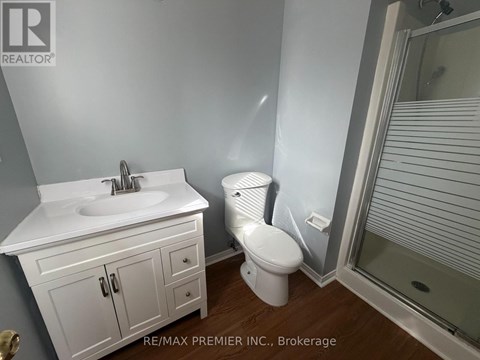 A white bathroom with a toilet, sink, and shower.